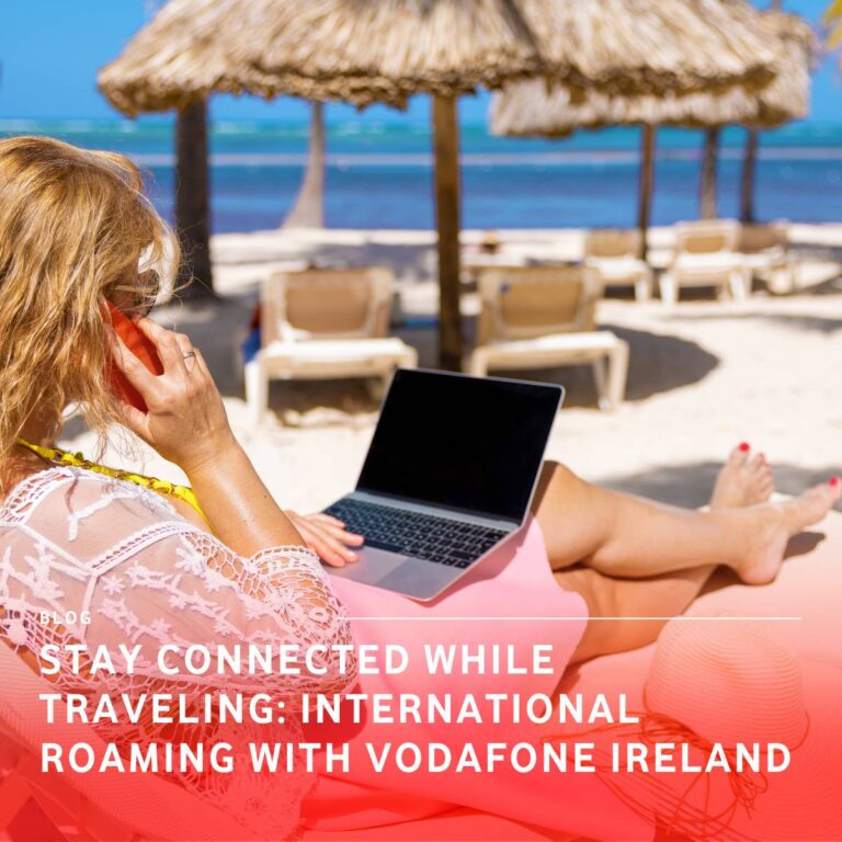 A lady sitting on a sun lounger on a beach with a laptop on her legs and phone to her ear